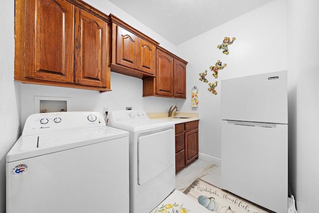 laundry room with cabinet space, baseboards, independent washer and dryer, marble finish floor, and a sink