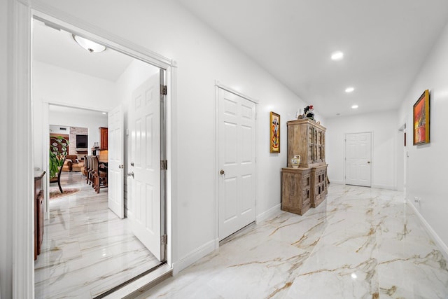 corridor with marble finish floor, baseboards, and recessed lighting