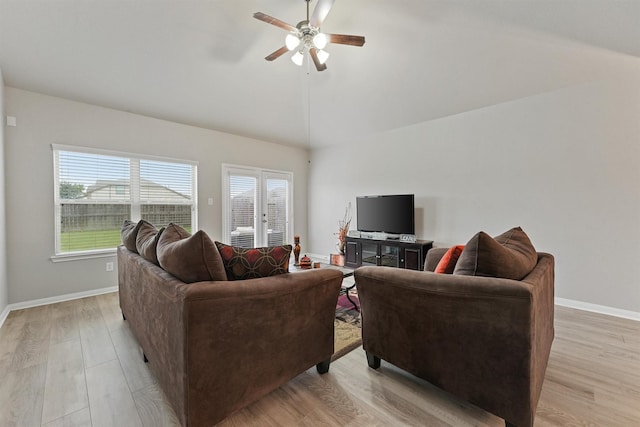 living room with ceiling fan, light hardwood / wood-style flooring, and vaulted ceiling