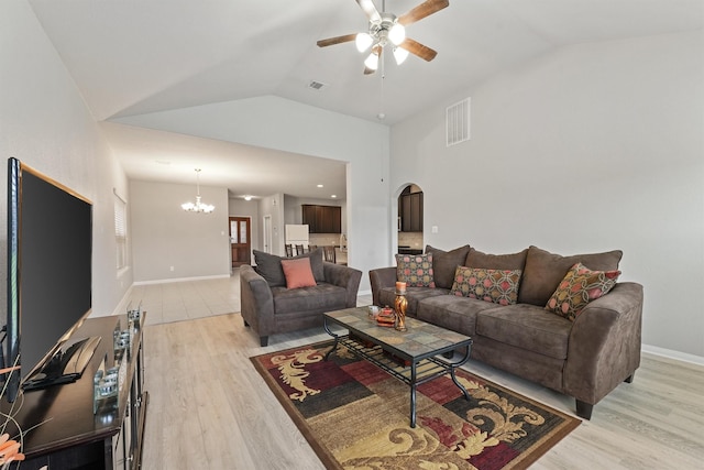 living room with vaulted ceiling, light hardwood / wood-style floors, and ceiling fan with notable chandelier