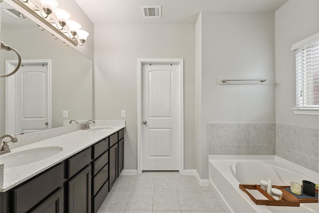 bathroom featuring tile patterned flooring, vanity, and a tub to relax in