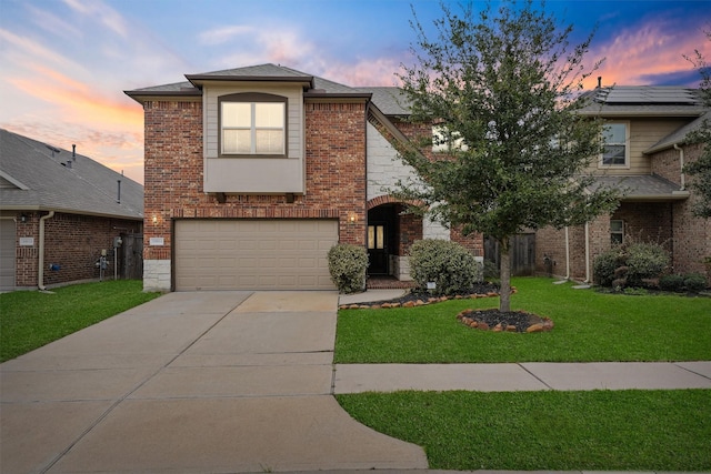 view of front property featuring a garage and a yard