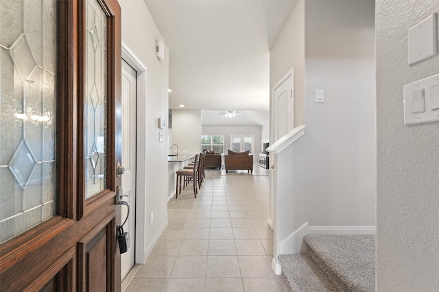 entrance foyer featuring sink and light tile patterned flooring