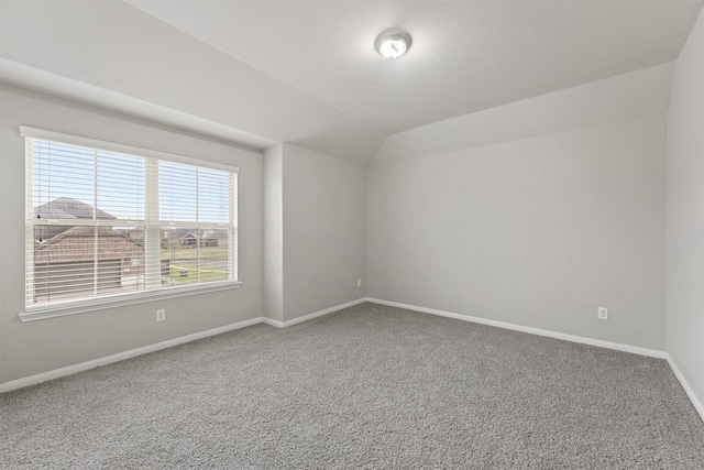 spare room with carpet floors and lofted ceiling