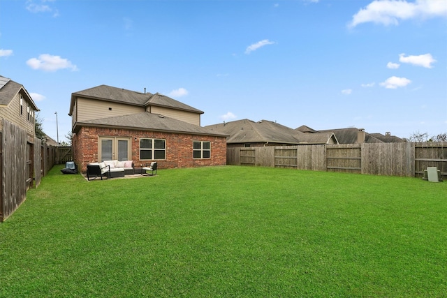 rear view of house featuring outdoor lounge area and a lawn