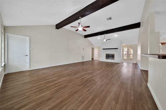 unfurnished living room with visible vents, vaulted ceiling with beams, baseboards, a fireplace, and wood finished floors