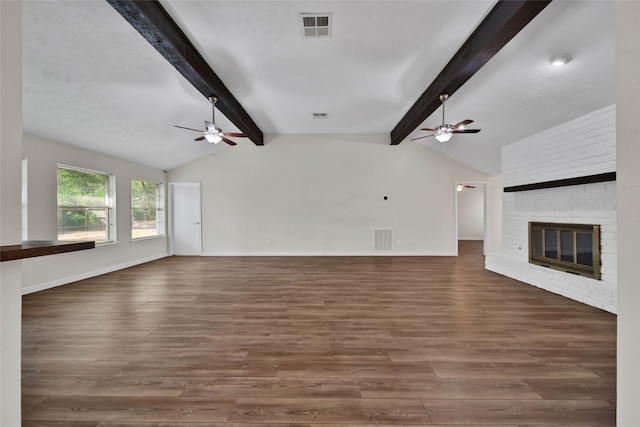 unfurnished living room featuring visible vents, a fireplace, vaulted ceiling with beams, and wood finished floors