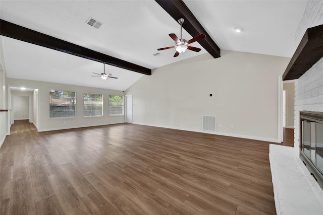 unfurnished living room with wood finished floors, vaulted ceiling with beams, a fireplace, and visible vents