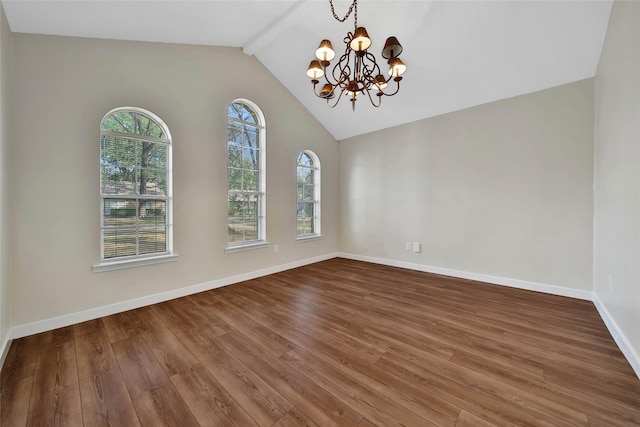 spare room featuring a chandelier, lofted ceiling with beams, baseboards, and wood finished floors