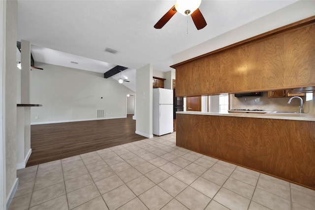 kitchen with visible vents, ceiling fan, open floor plan, freestanding refrigerator, and a sink