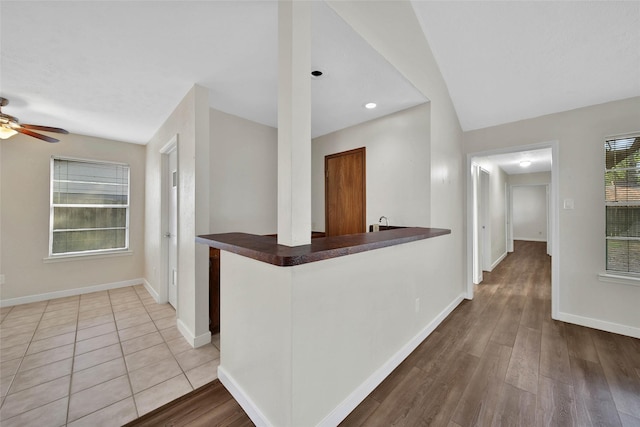 hallway featuring baseboards and wood finished floors