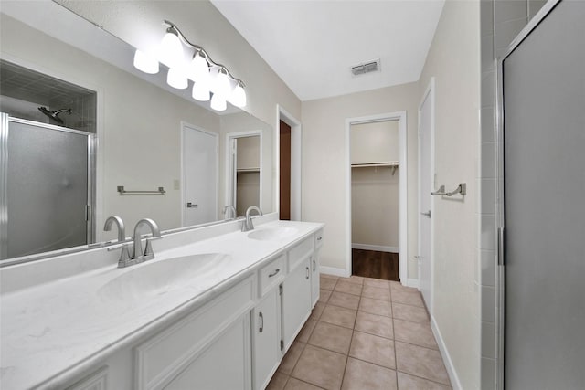 bathroom with tile patterned floors, a stall shower, visible vents, and a sink