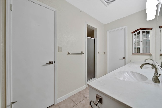 bathroom with vanity, baseboards, visible vents, a stall shower, and tile patterned flooring