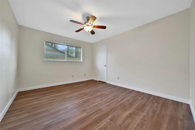 unfurnished room featuring a ceiling fan, wood finished floors, and baseboards