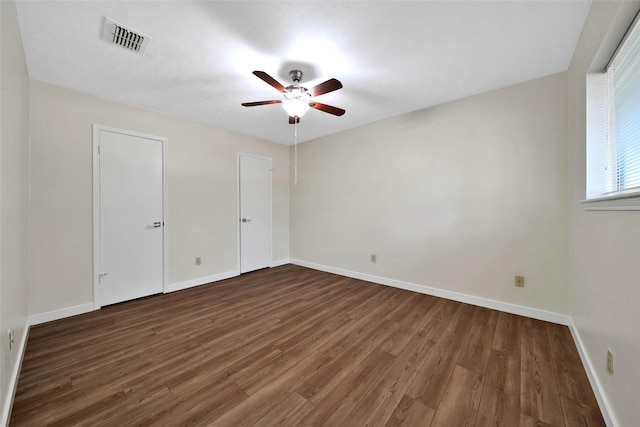 unfurnished bedroom with visible vents, baseboards, wood finished floors, and a ceiling fan