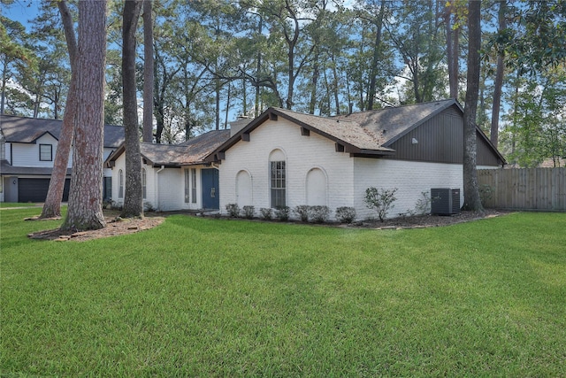 view of front of property featuring a front yard, fence, and brick siding