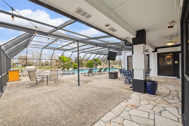 view of patio / terrace featuring ceiling fan and glass enclosure