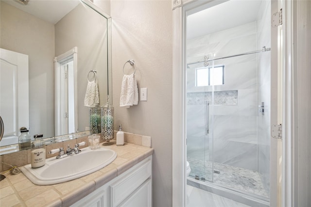 bathroom with toilet, a shower with door, and vanity