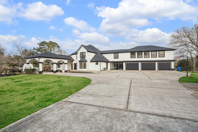 french provincial home with a front yard and a garage