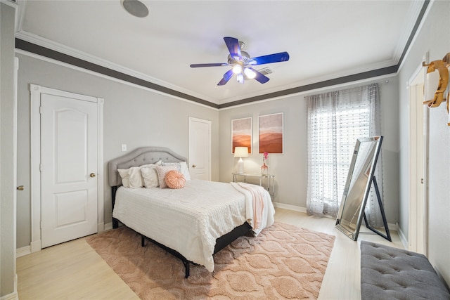 bedroom featuring light hardwood / wood-style flooring, ceiling fan, and ornamental molding