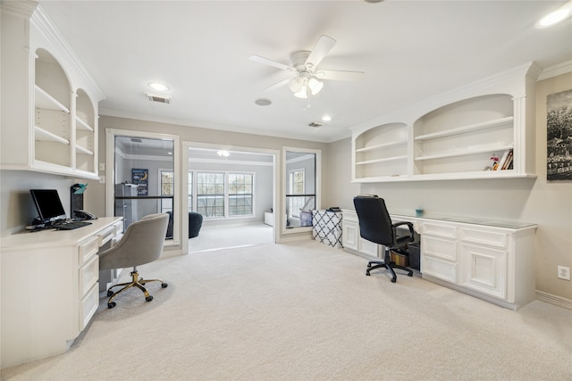 office area featuring light carpet, ceiling fan, built in desk, and ornamental molding