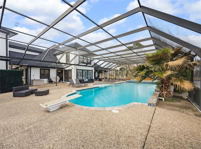 view of swimming pool featuring a diving board, glass enclosure, and a patio area