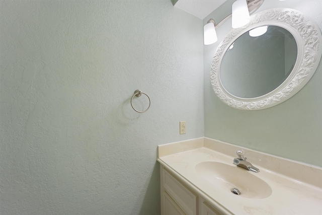 bathroom with a textured wall and vanity