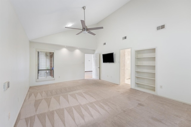 carpeted empty room with visible vents, lofted ceiling, a ceiling fan, and built in features