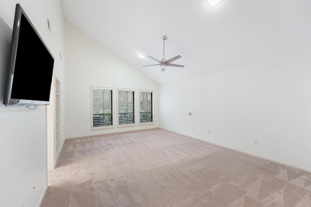 carpeted spare room with high vaulted ceiling and a ceiling fan