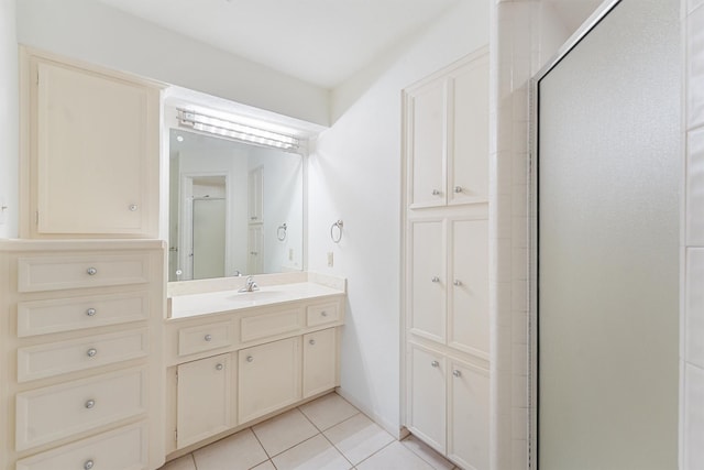 bathroom with tile patterned flooring, a shower stall, and vanity