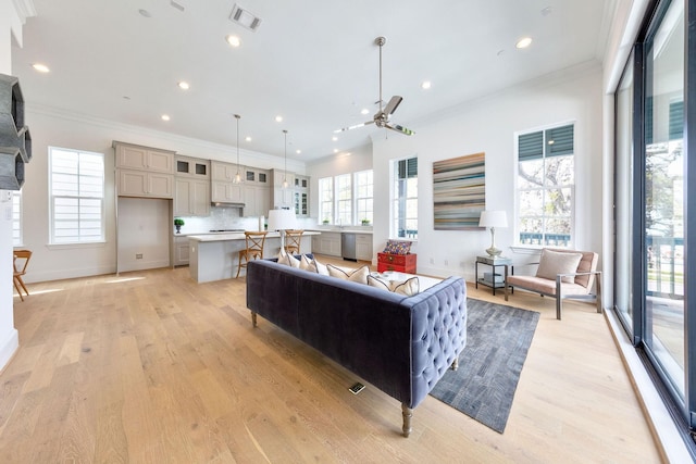 living room featuring crown molding and light hardwood / wood-style flooring