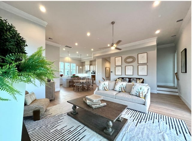 living room with ornamental molding and light wood-type flooring