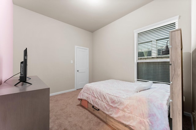 bedroom featuring light carpet and baseboards