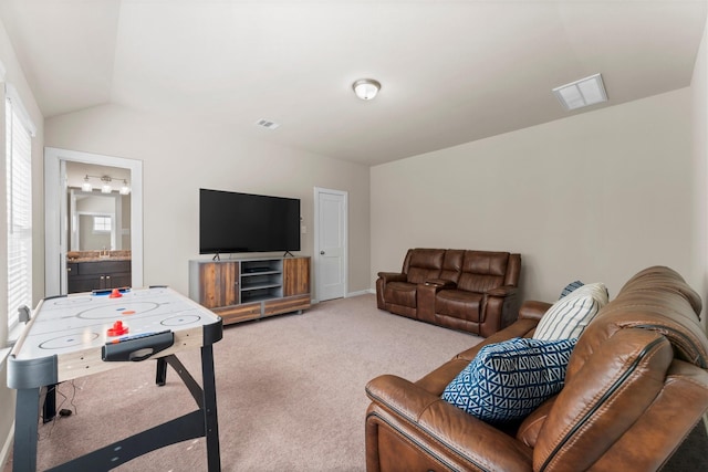 living area featuring carpet floors, visible vents, and lofted ceiling