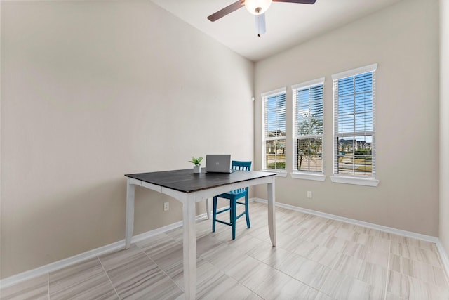 office space featuring ceiling fan and baseboards