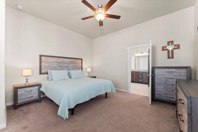 bedroom featuring light carpet, connected bathroom, a ceiling fan, and baseboards