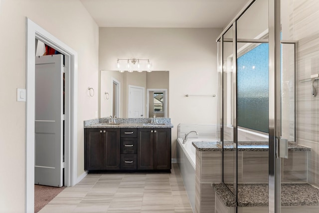 bathroom with a garden tub, double vanity, a sink, and a shower stall