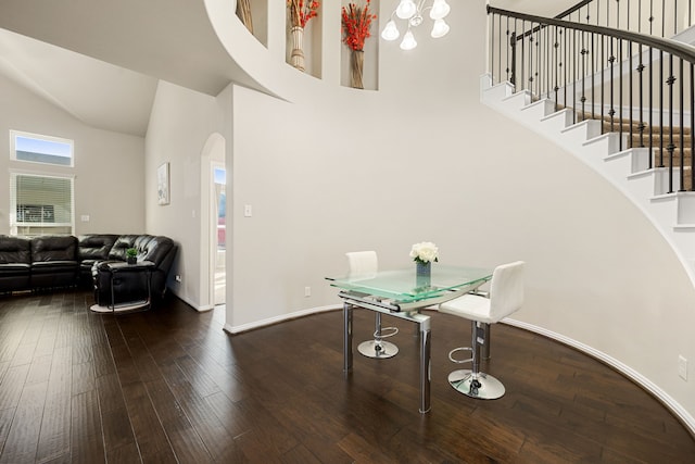 interior space with baseboards, arched walkways, dark wood-style flooring, stairs, and high vaulted ceiling