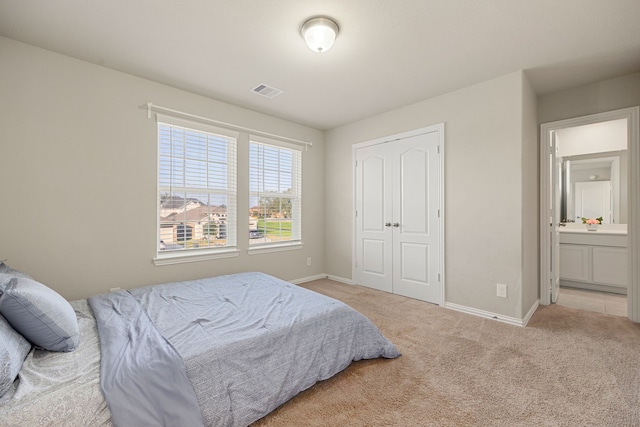 bedroom featuring visible vents, baseboards, a closet, and light colored carpet