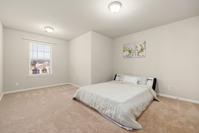 bedroom with light carpet and baseboards