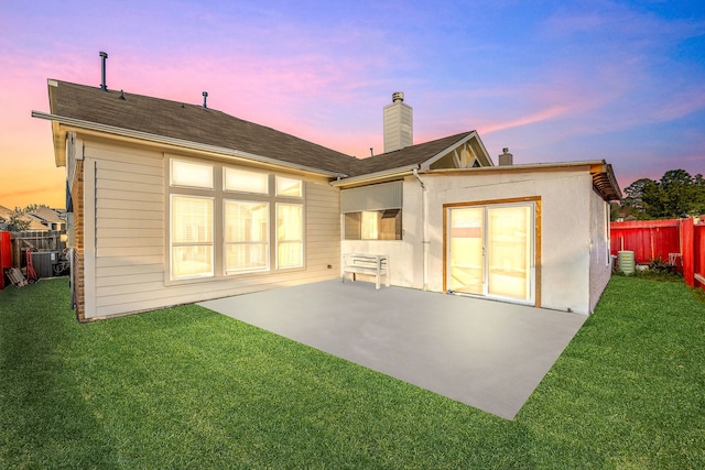 back of house with a patio, central air condition unit, fence, a yard, and a chimney