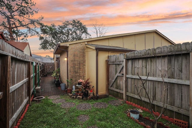 property exterior at dusk with a lawn