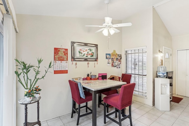 dining space with lofted ceiling, ceiling fan, and light tile patterned floors