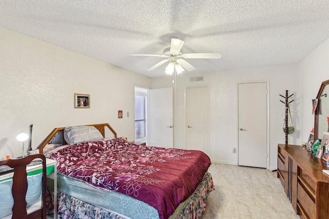 bedroom with ceiling fan and a textured ceiling