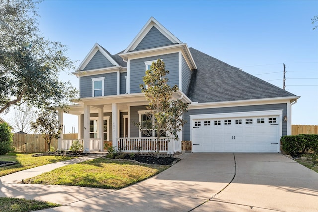 view of front of property featuring a front lawn, a porch, and a garage