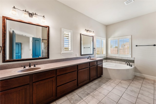 bathroom with vanity, a bath, and tile patterned floors