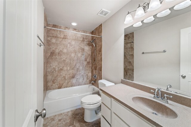 full bathroom featuring toilet, vanity, and tiled shower / bath