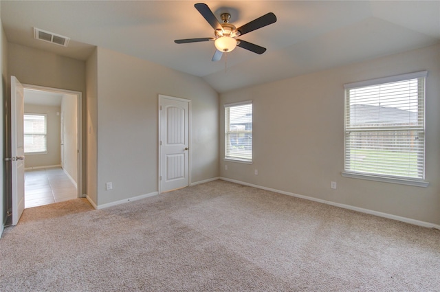 unfurnished bedroom featuring ceiling fan, vaulted ceiling, and light carpet