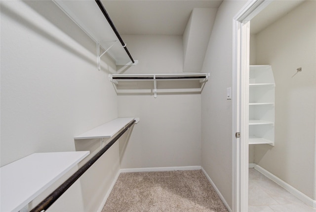 walk in closet featuring light colored carpet