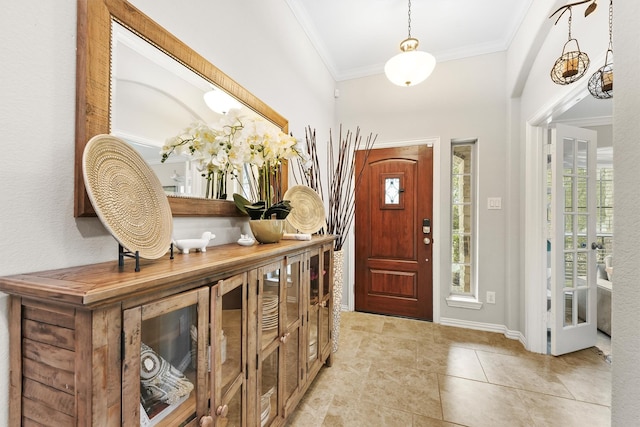 foyer with ornamental molding, baseboards, and light tile patterned floors